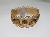une photo d'un bracelet en or posé sur une surface blanche, avec une étiquette de prix
