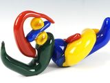 une figurine colorée représentant un oiseau perché au sol