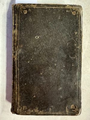 un vieux livre posé sur une table recouverte d'un tissu blanc