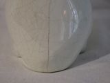 a white vase sitting on a table with a white cloth