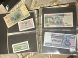 a lot of different types of paper money in a binder