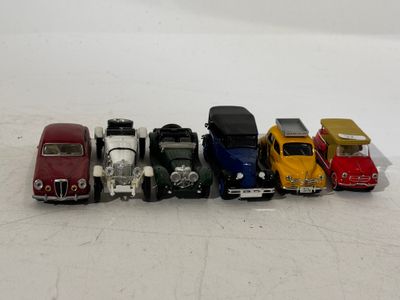 several toy cars are lined up in a row on a white surface