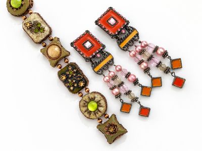 une photo en gros plan d'un collier et de boucles d'oreilles posés sur une surface blanche