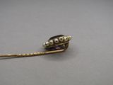 a close up of a gold brooch with pearls on it