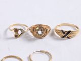 several gold rings and rings are arranged on a white surface