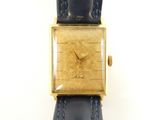 une image représentant une montre en or avec un bracelet bleu sur fond blanc