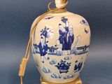 blue and white vase with a cord attached to it on a stand