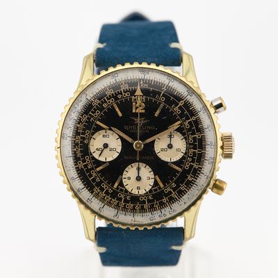 une photo d'une montre dorée et noire avec un bracelet bleu