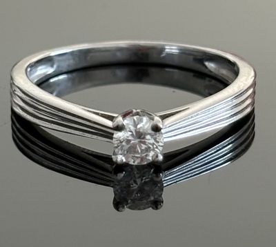 a close up of a diamond ring on a black surface