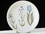 a white plate with blue flowers on it on a table