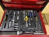 a red tool box with tools in it on the floor