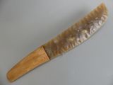 a knife that is on a plate with a wooden handle