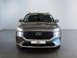the front view of a silver suv parked in a showroom