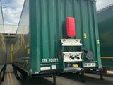deux semi-remorques verts garés l'un à côté de l'autre sur un parking