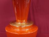 une lampe de table orange avec un abat-jour en verre sur fond rouge