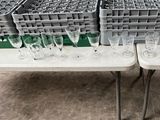 several empty wine glasses are sitting on a table in a warehouse