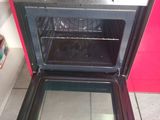 an oven with a door open on a tiled floor