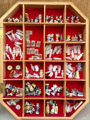 une vitrine en bois sur laquelle sont disposées de nombreuses figurines différentes