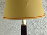 a lamp that is sitting on a table with a yellow shade