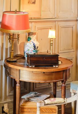 une petite table sur laquelle est posée une lampe, dans un coin de la pièce