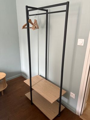 un porte-manteau dans un coin de la pièce, près d'une porte