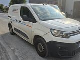 the van is parked on the side of the road in front of a building