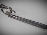 a metal tonget with a handle on a white surface