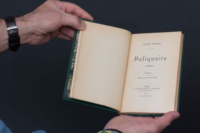un homme tenant un livre ouvert à la main