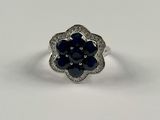 une bague en or blanc sertie d'un saphir bleu et de diamants