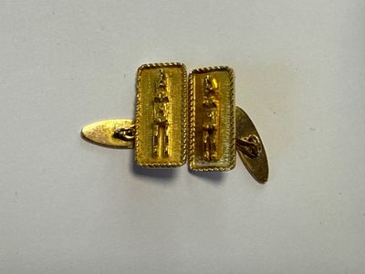 une valise dorée posée sur une surface blanche