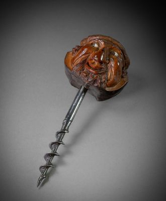 a close up of a bottle opener with a face on it