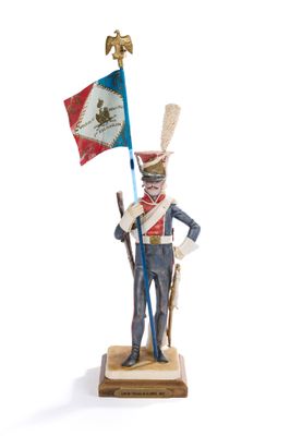 figurine of a soldier holding a flag and a flag pole