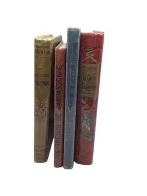 three books sitting next to each other on a white surface