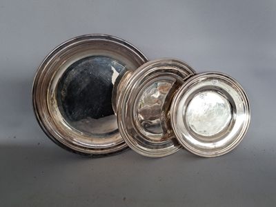 trois assiettes en argent avec des bords argentés sur un fond gris