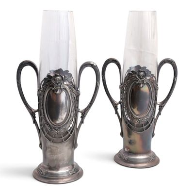 deux vases en argent posés l'un à côté de l'autre sur une surface blanche