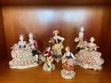 cinq figurines représentant des personnes assises sur une étagère