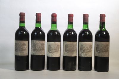 six bottles of wine are lined up on a white surface