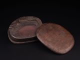 deux petites boîtes en bois ornées de sculptures sur un fond noir