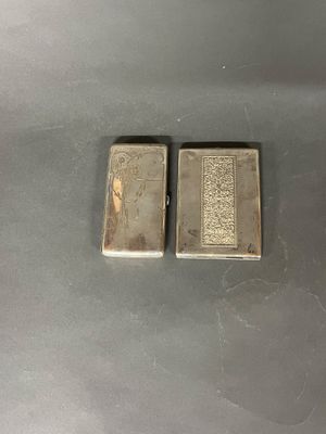deux briquets en argent posés l'un à côté de l'autre sur une table