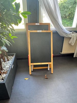 un petit tableau accroché dans un coin de la pièce, à côté d'une plante en pot