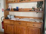 une armoire en bois surmontée d'une étagère, dans une cuisine