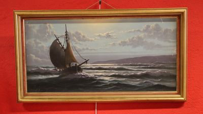 la photo d'un tableau accroché à un mur rouge
