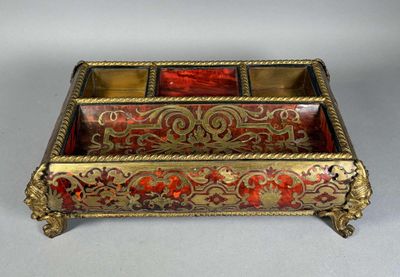 un coffret en verre or et rouge richement décoré, posé sur une surface blanche