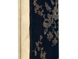 un vieux livre à la couverture noire posé sur une surface blanche