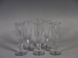 four empty wine glasses are lined up on a white surface