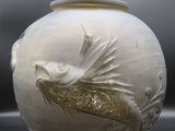 un vase blanc orné d'un motif représentant un poisson rouge