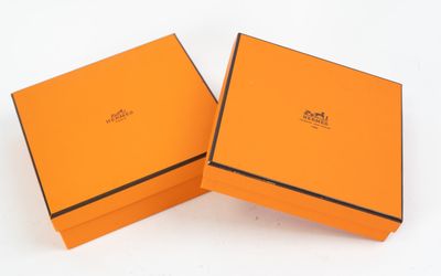 two orange boxes with black trims are open on a white surface