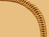 une image montrant un gros plan d'un collier en or sur fond beige