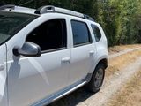 a white car parked on the side of a dirt road