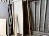several pieces of wood sit in front of a door in a warehouse